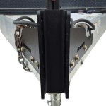 Trailer hitch coupler with safety chains mounted to a metal trailer frame.